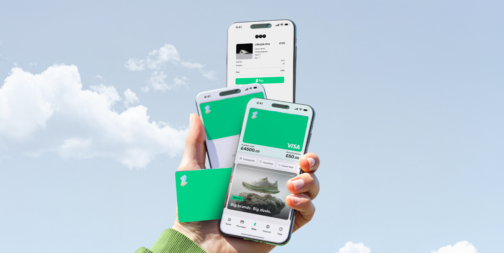A hand holds three smartphones showing a digital payments and shopping app alongside a matching payment card, set against a bright blue sky with soft clouds. The screens display a virtual card, checkout page and shopping offers.